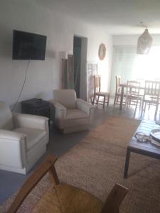 uma sala de estar com mobiliário branco e uma televisão de ecrã plano em Sierras de Paz em Villa Giardino