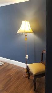 a lamp and a chair in a room at Charming Townhouse in Historic Town near Boston. in Dedham