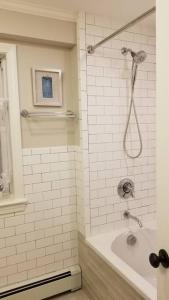 a bathroom with a shower with a tub and a sink at Charming Townhouse in Historic Town near Boston. in Dedham