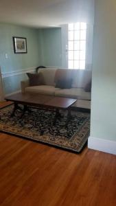 a living room with a couch and a coffee table at Charming Townhouse in Historic Town near Boston. in Dedham