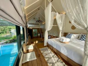 um quarto com uma cama e uma piscina em Baan Nai Baan Nok Resort em Nakhon Nayok