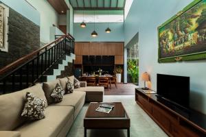 a living room with a couch and a tv at Agranusa Signature Villa Nusa Dua in Nusa Dua
