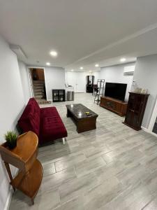 a living room with a red couch and a table at Airport Xpress Guestrooms in Philadelphia