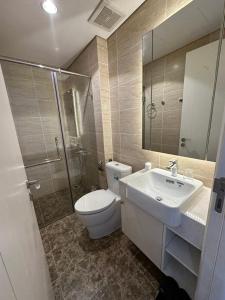 La salle de bains est pourvue de toilettes, d'un lavabo et d'une douche. dans l'établissement hamy’s house- studio vinhomes d’capital apartment 119 tran duy hung, à Hanoï