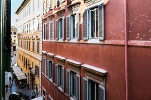 un edificio con ventanas con persianas en una calle de la ciudad en Trevi & Pantheon Luxury Rooms en Roma