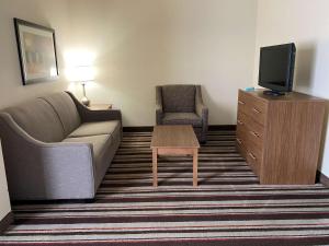 a living room with a couch and a tv and a table at Best Western Windsor Inn and Suites in Danville
