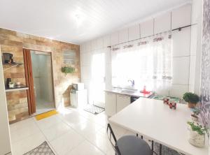 a kitchen with a table and a sink and a refrigerator at Kitnet Lua - Mobiliada in Belo Horizonte