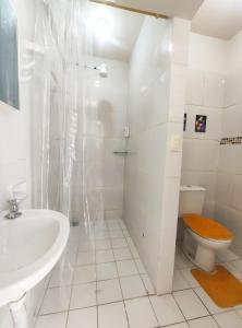 Baño blanco con lavabo y aseo en Kitnet Lua - Mobiliada, en Belo Horizonte