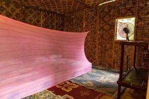 ein Schlafzimmer mit einem rosa Bett in einem Zimmer mit Fenster in der Unterkunft Rain Forest Inn in Ringlet