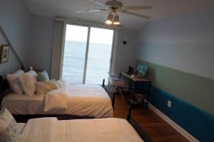 sypialnia z 2 łóżkami i oknem w obiekcie Casa al Mare Beachfront Retreat King Bed Near Yale w mieście East Haven