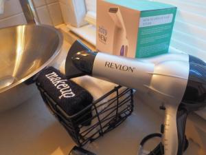 a hair dryer on a counter next to a sink at Casa al Mare Beachfront Retreat King Bed Near Yale in East Haven