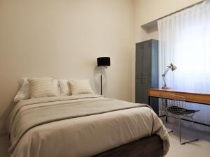 1 dormitorio con cama, escritorio y ventana en G&G Apartments - Recoleta Boutique Experience en Buenos Aires