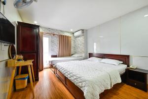 a bedroom with two beds and a television in it at Gia Hoa Airport Hotel in Ho Chi Minh City