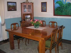 una mesa de madera con sillas y un jarrón de flores. en Tradicion Austral Bed & Breakfast, en Puerto Varas