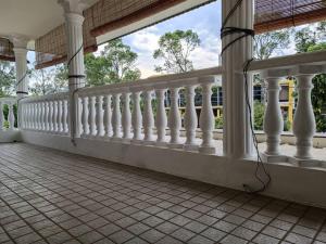 uma varanda com grades brancas numa casa em Cosy and family friendly house em Sungai Petani