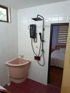 a bathroom with a bath tub and a bed at Cosy and family friendly house in Sungai Petani