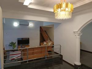 a living room with a chandelier and a staircase at Cosy and family friendly house in Sungai Petani