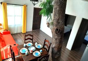 a table with plates on it next to a tree at Hotel del Bosque in Panajachel