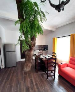 a living room with a table and a tree in it at Hotel del Bosque in Panajachel