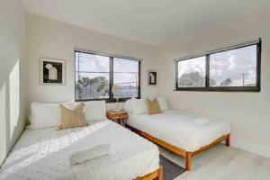 two beds in a room with two windows at Modern & Beachy-Rlx space for 6ppl in Fort Lauderdale