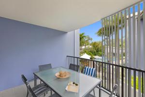 a dining room with a table and chairs on a balcony at Verano Resort Noosa in Noosaville