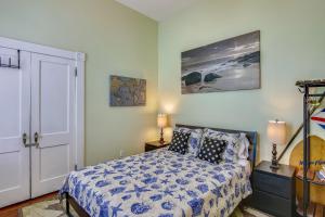a bedroom with a bed with a blue and white comforter at AbFab Seaside Cottage in Galveston