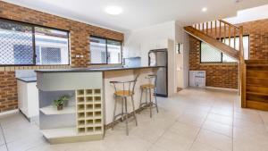 an open kitchen and living room with a brick wall at Magical holiday home - Welsby Pde, Bongaree in Bongaree +13 photos