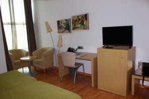 Habitación con cama y escritorio con TV. en Valcarce Ferrol, en Narón