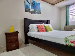 a bedroom with a bed with a wooden headboard and a night stand at Department H González 2 in Alajuela City