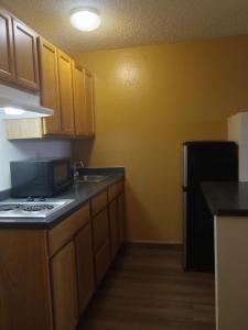 a kitchen with wooden cabinets and a black refrigerator at SilverStone Lite in Sunnyside