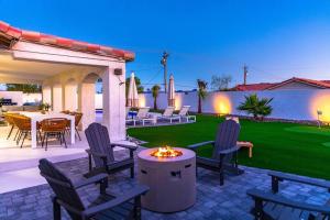 a patio with chairs and a table and a fire pit at Tropical Playhouse. Heated Pool . Spa . Golf . FUN in Lake Havasu City