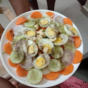 a plate of food with eggs and carrots at The Little Prince - Mangalore Beach Homestay in Mangalore