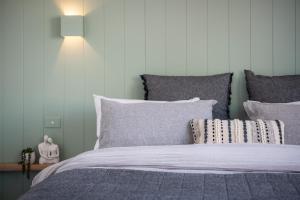 Un dormitorio con una cama con sábanas y almohadas púrpuras. en Little Jem en Daylesford