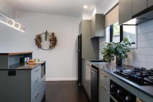 a kitchen with black counters and a stove top oven at Little Jem in Daylesford +5 photos