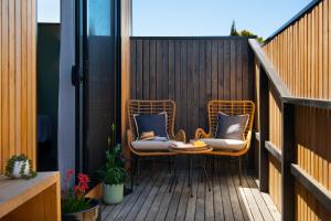 een patio met 2 stoelen op een houten terras bij Little Jem in Daylesford