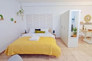- une chambre avec un grand lit et une couverture jaune dans l'établissement Relaxing Studio Apt, 1 min to Highway, Parking, à Athènes
