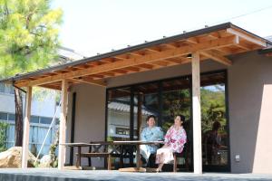 twee mensen zitten op de veranda van een gebouw bij Seirakuen in Atsugi