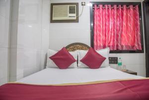 a bedroom with a large bed with red curtains at RELAX GUEST HOUSE in Mumbai