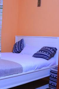 a bed with blue and white pillows on it at Fifi's in Kitui
