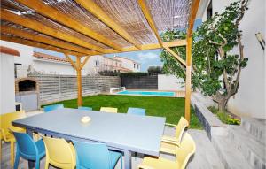 eine Terrasse mit einem Tisch, Stühlen und einem Pool in der Unterkunft Amazing Home In Torreilles With Heated Swimming Pool in Torreilles