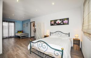 Schlafzimmer mit einem großen Bett mit weißer Bettwäsche und blauen Wänden in der Unterkunft Amazing Home In Torreilles With Heated Swimming Pool in Torreilles