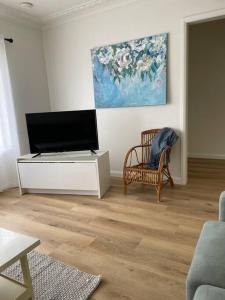 a living room with a flat screen tv and a chair at COD & C0 Tocumwal in Tocumwal