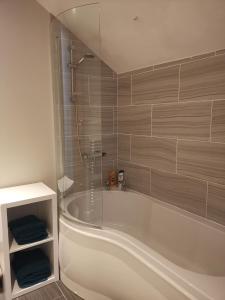 een badkamer met een wit bad en een douche bij NEW Derby Pride Park Arena Moorways 4 bedrooms 7 beds -Spacious contractors or group -FREE PARKING in Derby