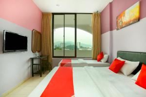 a hotel room with two beds and a large window at OYO 43933 Ferringhi Stay Iinn in Batu Ferringhi