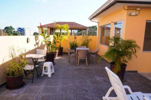 un patio al aire libre con mesas, sillas y plantas en Hotel Palace Ejecutivo en San Pedro Sula