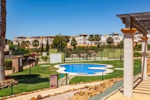 a swimming pool in a park with buildings in the background at Casa Manuela in Vera