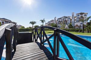 a wooden bridge over a pool with buildings in the background at Casa Manuela in Vera