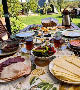 una tavola ricoperta di piatti di cibo su un tavolo di Byelka Bungalov Ayvalık a Ayvalık
