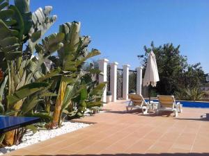 un patio con 2 sillas y una sombrilla junto a la piscina en Villa 81 amazing villa in a fantastic location on Oura Beach Albufeira, en Albufeira