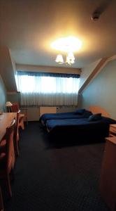 Cette chambre comprend 2 lits et une fenêtre. dans l'établissement Hotel Pasymowski, à Mława